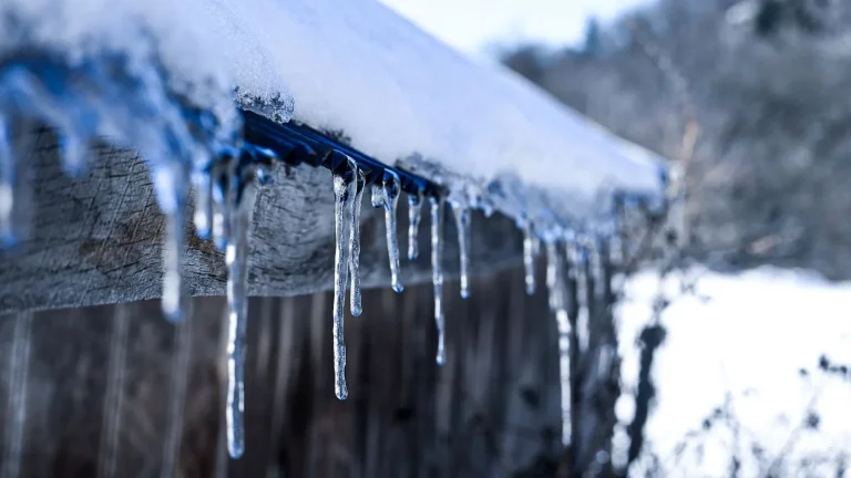 Icicles hanging from a snow-covered roof, ice dam prevention in Duluth, MN