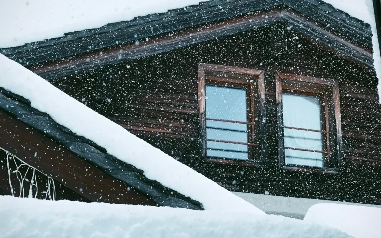 Snow on the roof of a brick home, roofers in Proctor, MN