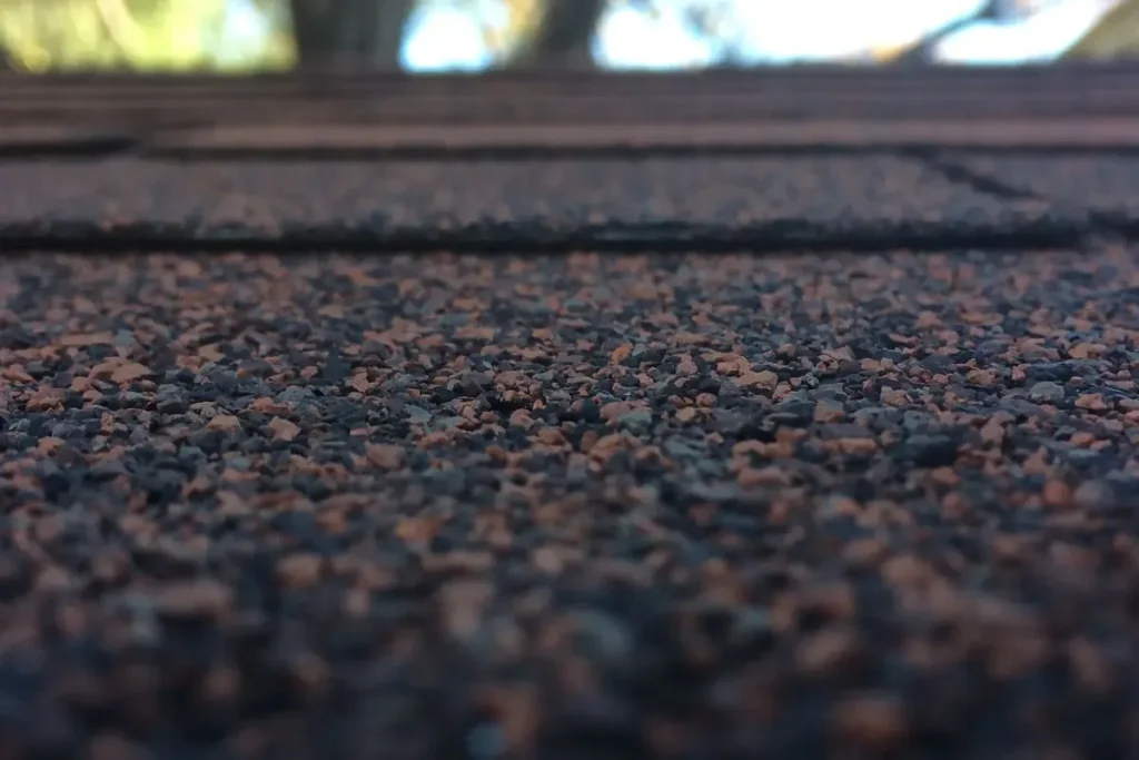 Worn asphalt shingles with granule loss from hail and weather